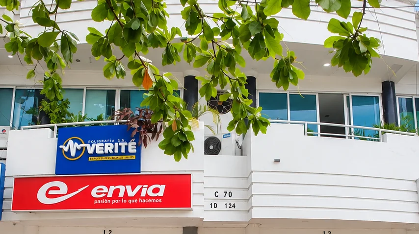 Fachada de la oficina de VERITÉ con su rótulo azul en el primer piso alto
